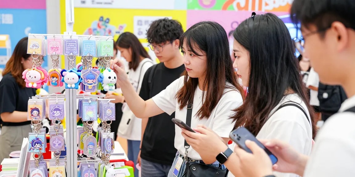 Customers exploring custom keychains at a lively retail booth, showcasing vibrant and unique designs.